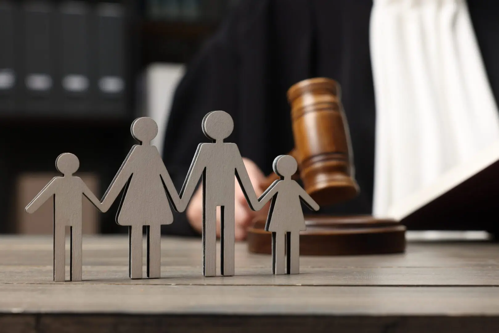 Judge with gavel behind family figurines.